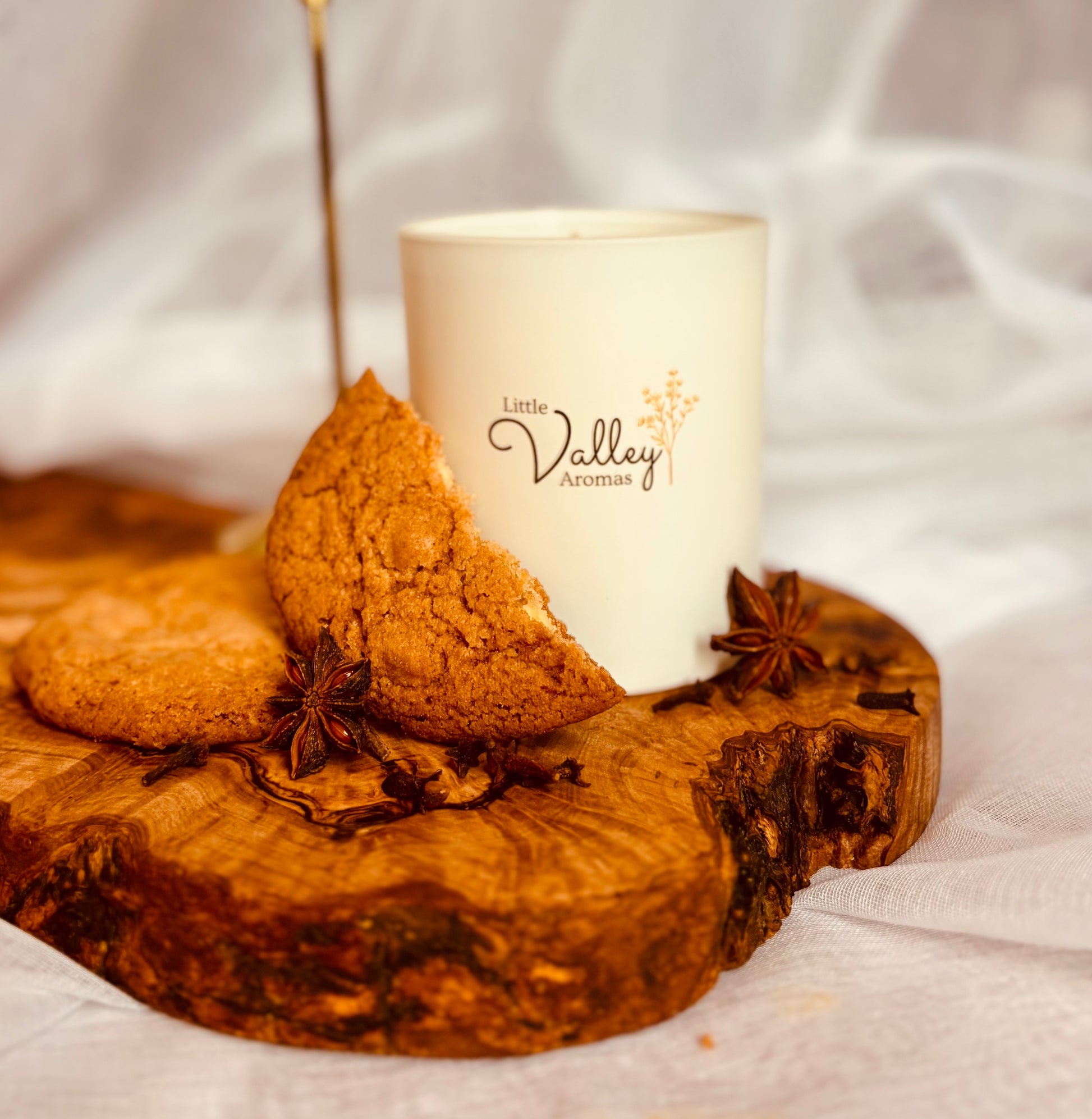 Candle with star anise on a wooden board, featuring 'Little Valley Aromas' branding.
